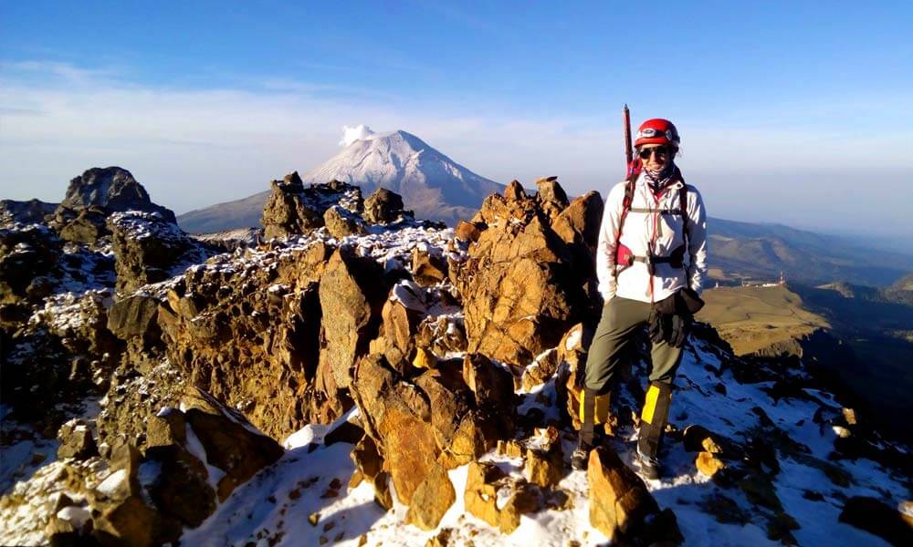 Mariana Torres en la cima del Iztaccihuatl, atrás el Popocatépetl
